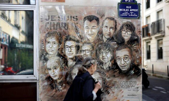 A woman walks past a painting by French street artist and painter Christian Guemy in tribute to members of Charlie Hebdo newspaper who were killed by jihadist gunmen in January 2015, in Paris, on Aug. 31, 2020. (Thomas Coex/AFP via Getty Images)
