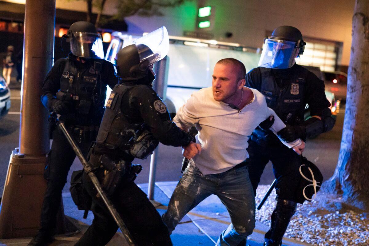 Portland police hold back Chandler Pappas who was with the victim of a fatal shooting as he reacts in minutes after the incident, in Portland, Ore., on Aug. 29, 2020. (Nathan Howard/Getty Images)