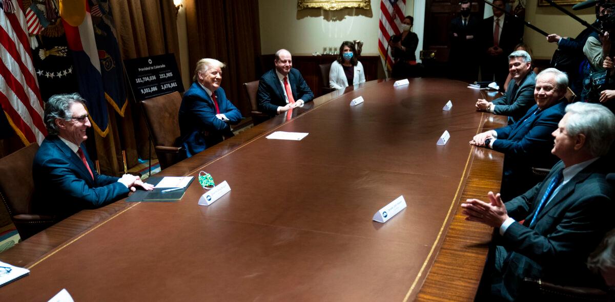 North Dakota Gov. Doug Burgum, left, President Donald Trump, second from left, and Colorado Governor Jared Polis, third from left, during a meeting in the Cabinet Room of the White House in Washington on May 13, 2020. (Doug Mills/Pool/Getty Images)