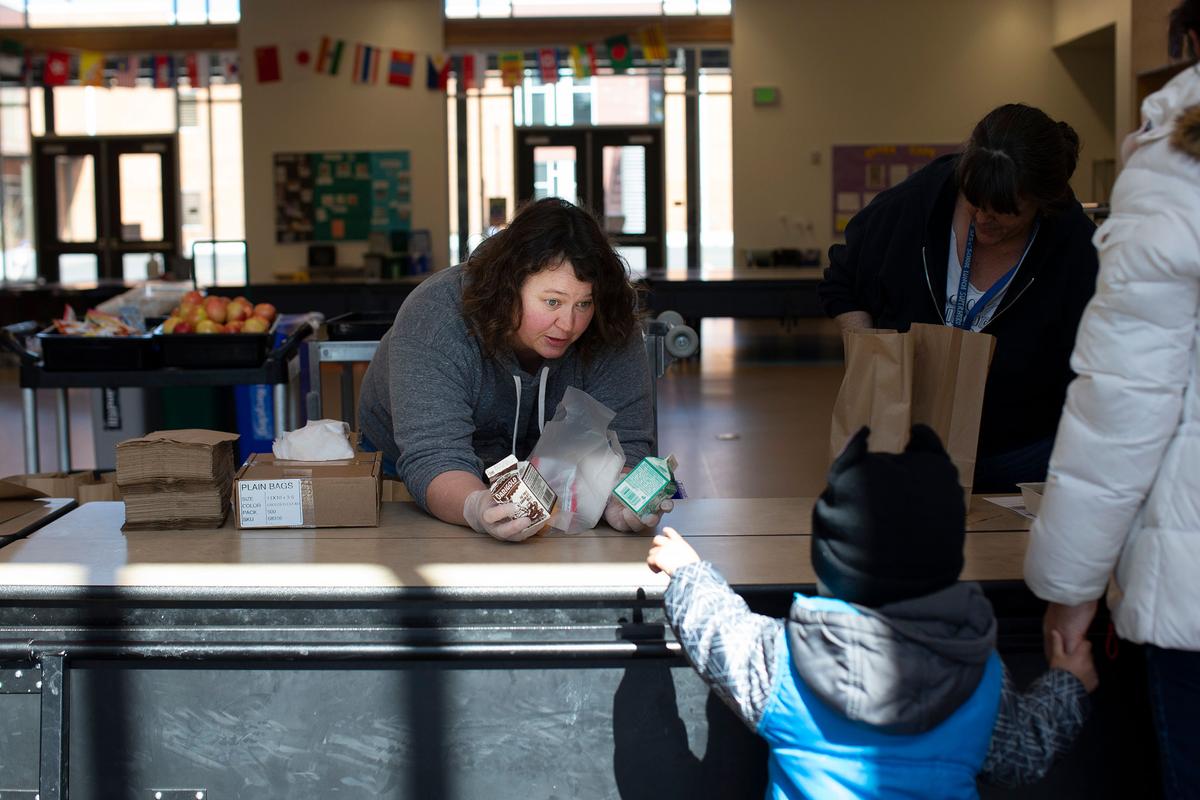 Christy Cusick hands out free school lunches to kids and their parents at Olympic Hills Elementary School on March 18, 2020, in Seattle, Wash. (Karen Ducey/Getty Images)