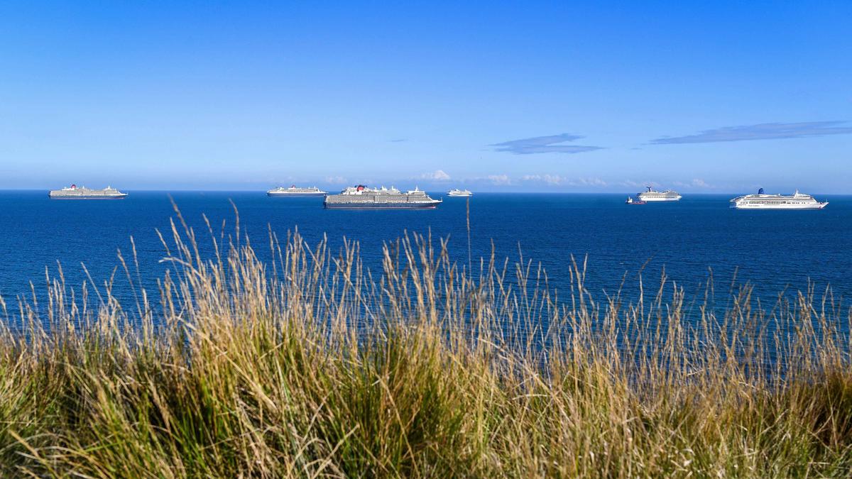 Cruise ships (L-R) Queen Victoria, Queen Mary 2, Queen Elizabeth, Marella Discovery, Carnival Valor, and Aurora anchored in the English Channel off the Dorset coast as the industry remains at a standstill due to the pandemic on Aug. 18, 2020, in Weymouth, England (Finnbarr Webster/Getty Images)
