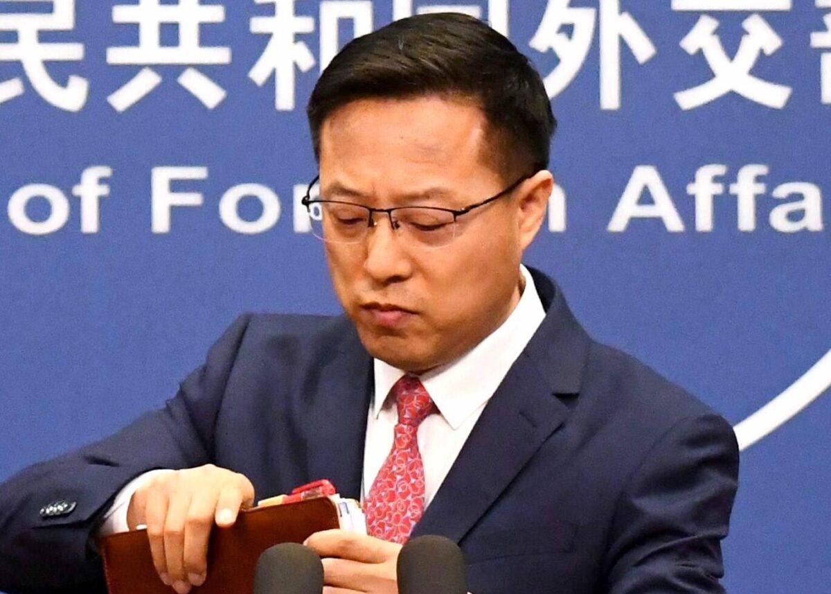 Chinese Foreign Ministry spokesman Zhao Lijian packs up his notes after speaking at the daily media briefing in Beijing on April 8, 2020. (Greg Baker/AFP via Getty Images)