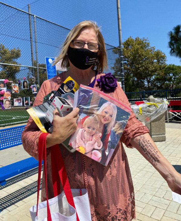 Costa Mesa resident Julie May holds a picture of her daughter, Jessica, who died from a drug overdose, and displays a new tattoo inked in honor of her memory on International Overdose Awareness Day in Laguna Niguel, Calif., on Aug. 31, 2020. (Chris Karr/The Epoch Times)