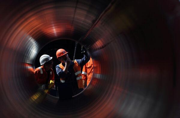 Workers are seen through a pipe at the construction site of the Nord Stream 2 gas pipeline, near the town of Kingisepp, Leningrad region, Russia, on June 5, 2019. (Anton Vaganov/Reuters)