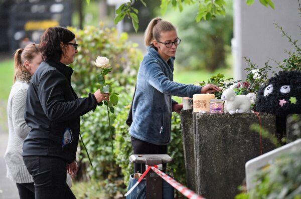 People bring flowers and candles to an apartment building, where five dead children were found in Solingen, Germany, on Sept. 4, 2020. (Martin Meissner/AP Photo)