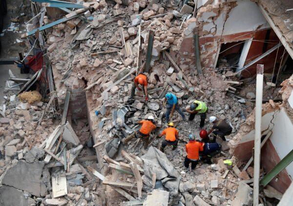 Lebanese and Chilean rescuers search in the rubble of a collapsed building after getting signals there may be a survivor, in Beirut, Lebanon, on Sept. 4, 2020. (Hussein Malla/AP Photo)