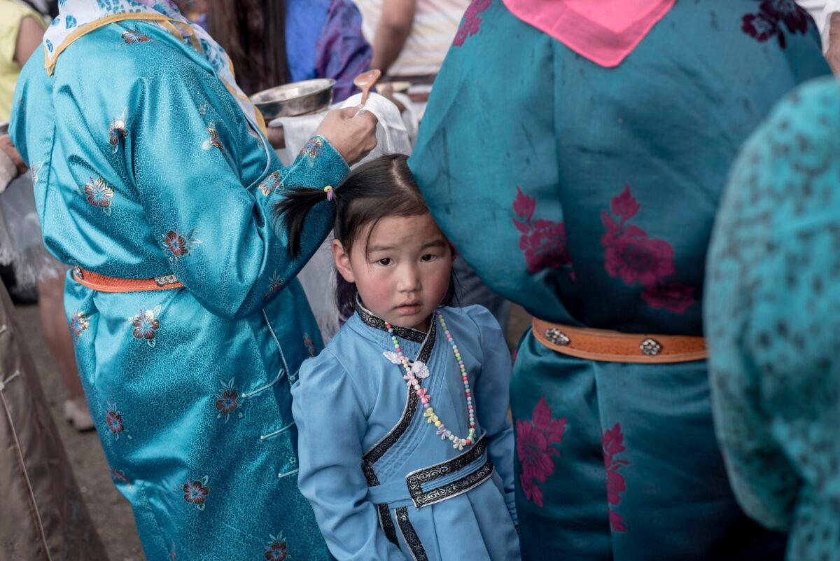 A girl wearing a traditional Mongolian costume waits with her mother during the speech of Mongolian presidential election candidate Battulga Khaltmaa from the Mongolian Democracy Party during a rally in Ulan Bator, on June 23, 2017.<br/>(Fred Dufour/AFP via Getty Images)