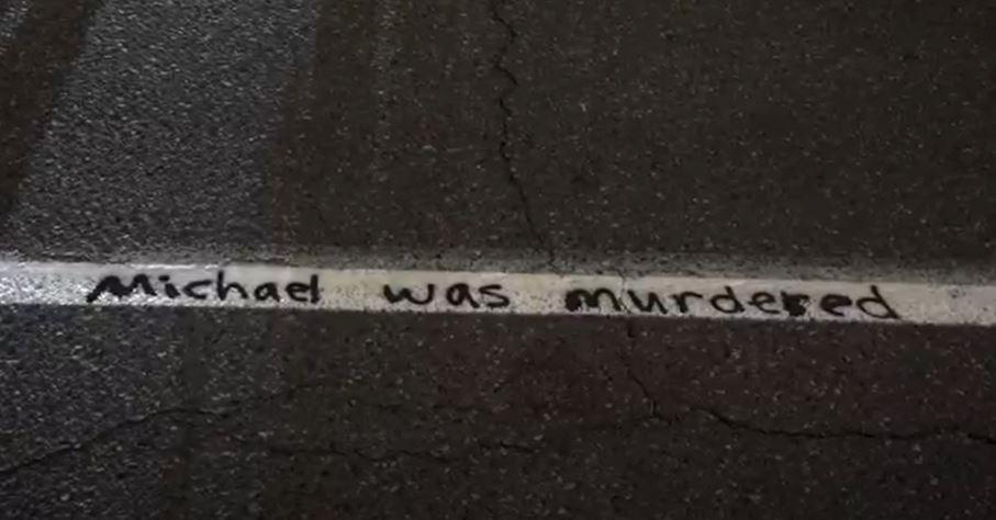 In this still image from video, the words "Michael was murdered" are scrawled on the pavement during a demonstration in Portland, Ore., on Sept. 3, 2020. (Roman Balmakov/The Epoch Times)