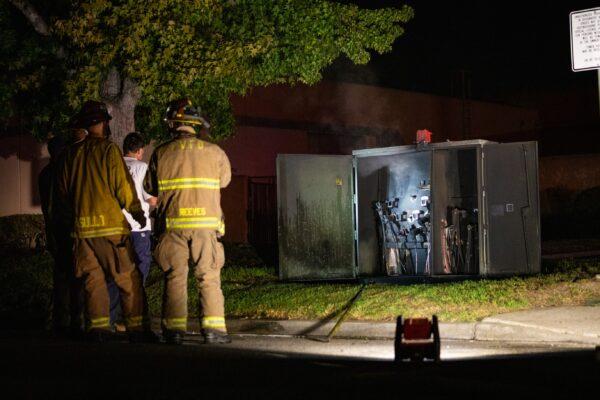 Firefighters stand near an electric box that caught fire in Fountain Valley, Calif., on Sept. 4, 2020. (John Fredricks/The Epoch Times)