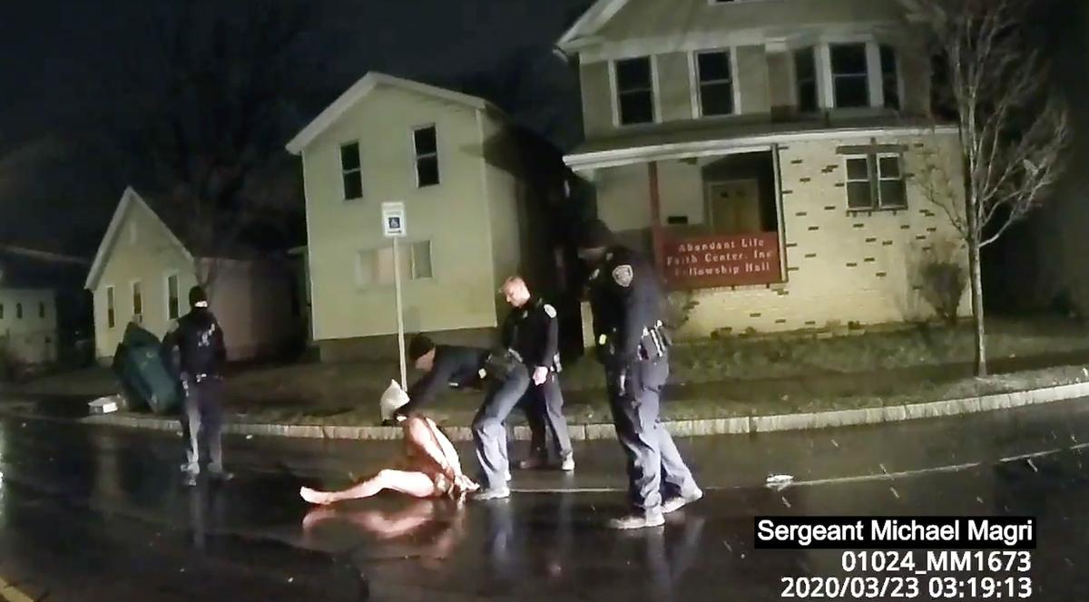 In this still image from police body camera video, a Rochester police officer puts a hood, known as a "spit sock," over the head of Daniel Prude in Rochester, N.Y., on March 23, 2020.
