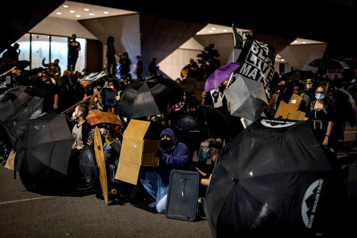 People use umbrellas and shields during clashes with police officers in Rochester, N.Y., on Sept. 4, 2020. (Maranie R. Staab/AFP via Getty Images)