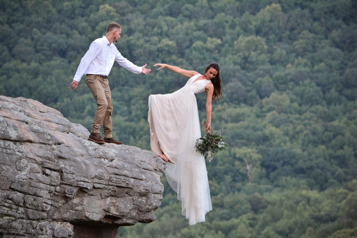 Ryan and Skye pose at the edge of the cliff for a breathtaking image. (Caters News)