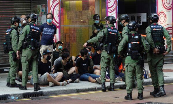 People, sitting on the ground, are arrested by police officers at a downtown street in Hong Kong, on Sunday, Sept. 6, 2020. (Vincent Yu/AP Photo)