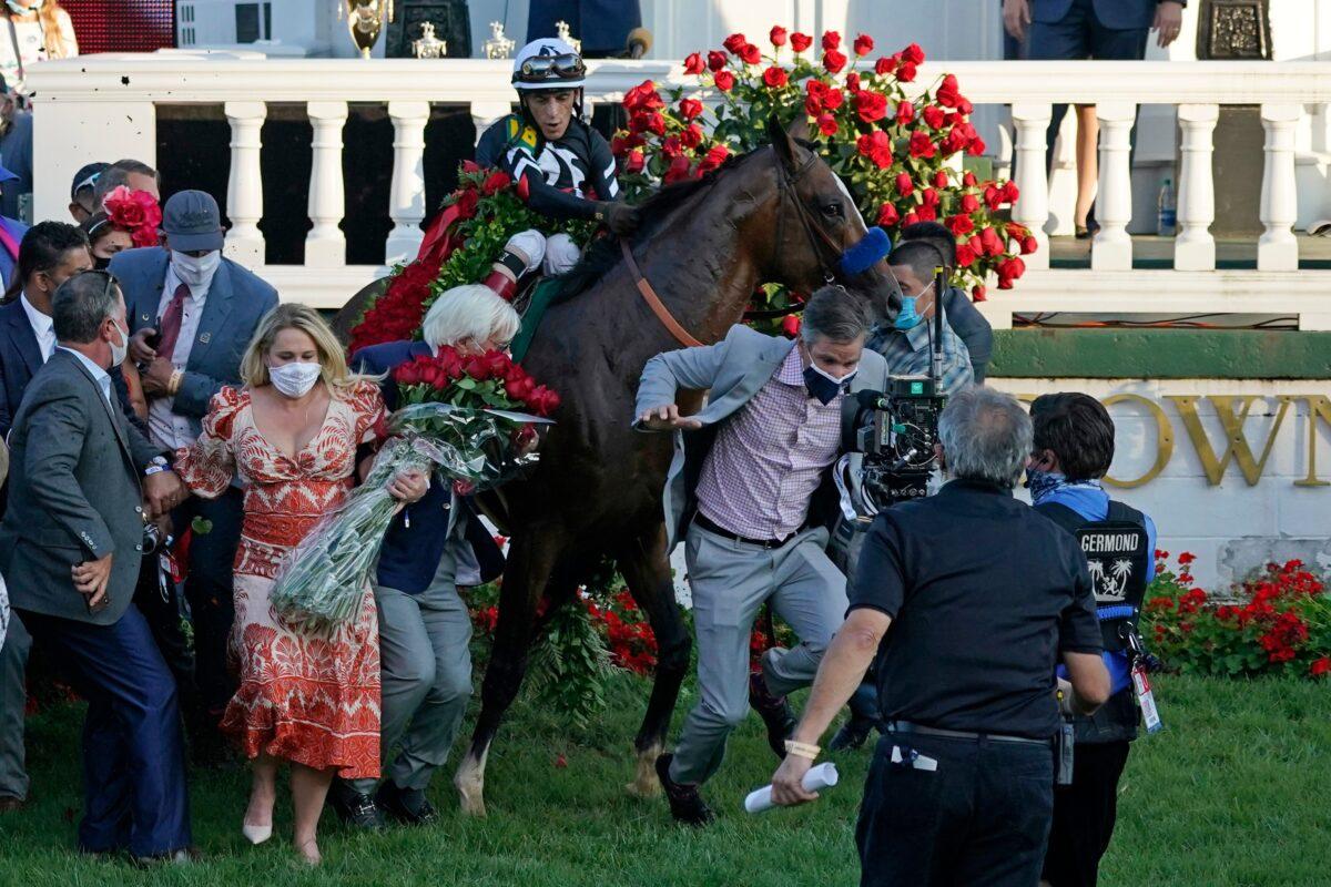 Trainer Bob Baffert attempts to get out of the way as Jockey John Velazquez tries to control Authentic in the winners' circle after winning the 146th running of the Kentucky Derby at Churchill Downs, in Louisville, Ky., on Sept. 5, 2020. (Jeff Roberson/AP Photo)