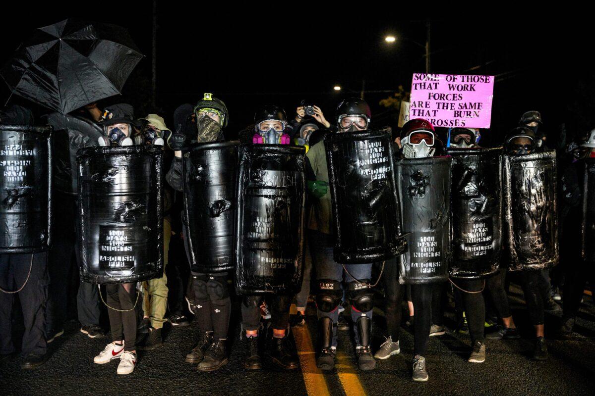People carrying shields that say "Abolish PPB," or the police, during a march that devolved into a riot in Portland, Ore., late Sept. 5, 2020. (Allison Dinner/AFP via Getty Images)
