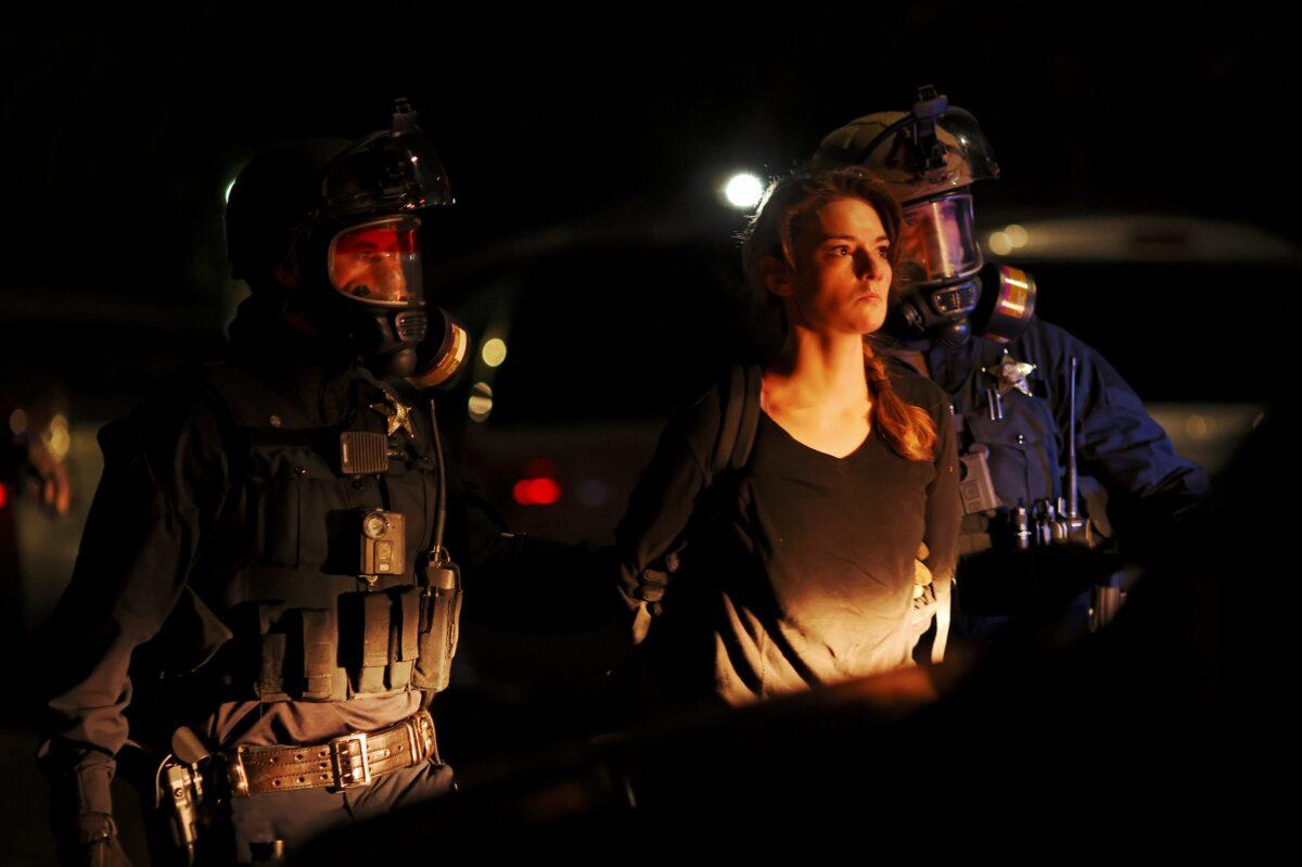 A woman is detained by police officers during a riot in Portland, Ore., late Sept. 5, 2020. (Carlos Barria/Reuters)