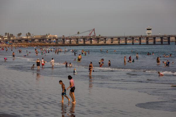 Beachgoers cool off in the ocean at Seal Beach, Calif., during a heat wave on Sept. 6, 2020. (John Fredricks/The Epoch Times)