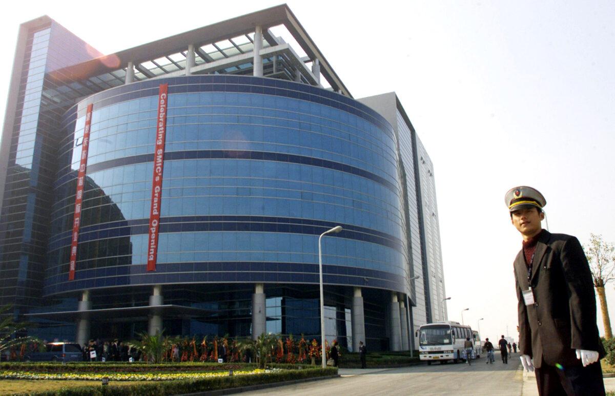 A security officer stands outside a building of Semiconductor Manufacturing International Corp. during its grand opening in Shanghai on Nov. 22, 2001. (Reuters)