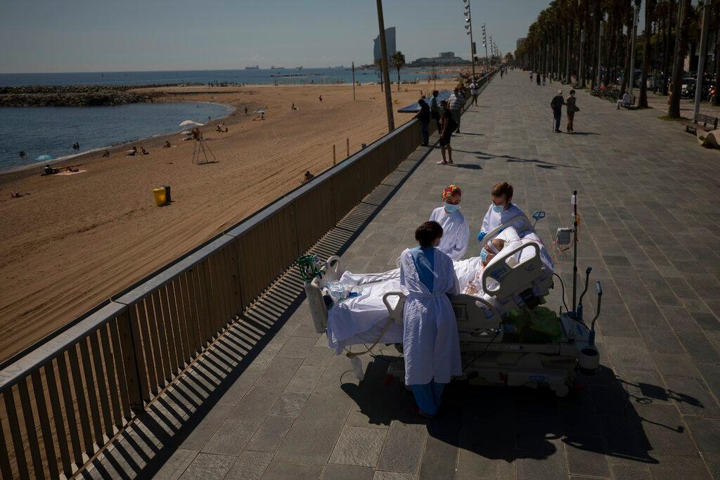 Francisco España is surrounded by members of his medical team as he looks at the Mediterranean sea from a promenade next to the "Hospital del Mar" in Barcelona, Spain. (Emilio Morenatti/AP)