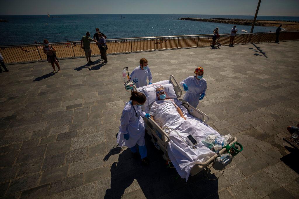Francisco España is transported back to the hospital after spending a few minutes by the promenade in Barcelona, Spain. (Emilio Morenatti/AP)