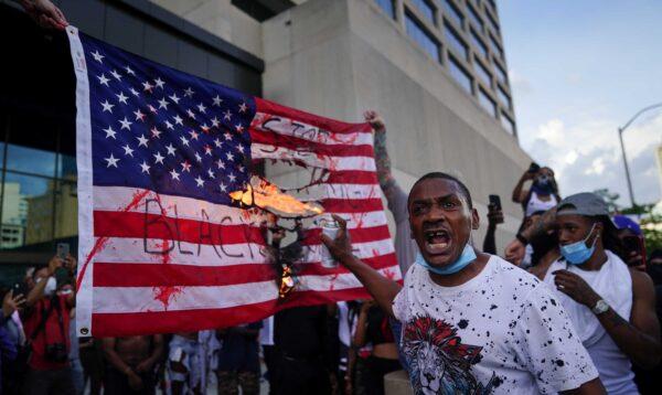 Protesters burn a flag outside the CNN Center in Atlanta, Ga., on May 29, 2020. (Elijah Nouvelage/Getty Images)