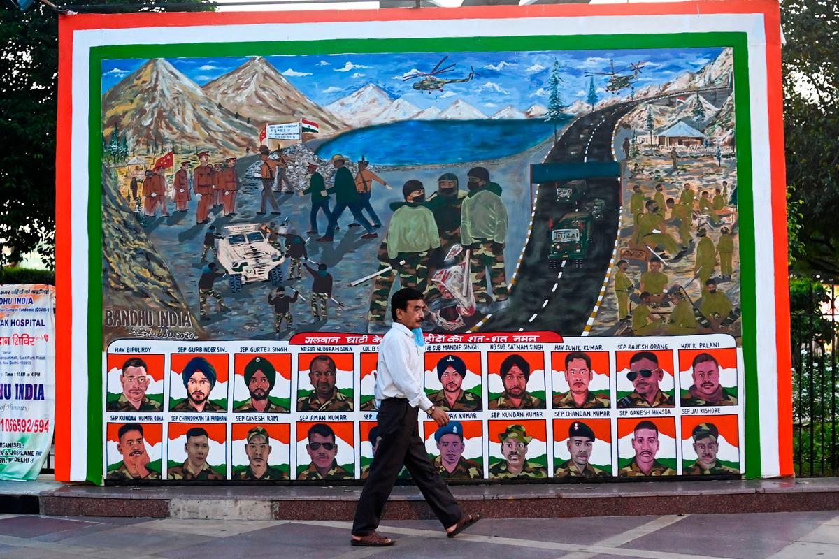 A man walks past a poster depicting portraits of Indian soldiers killed in a hand-to-hand fight with their Chinese counterparts on June 15, 2020, in a market area in New Delhi, on Aug. 31, 2020. (Jewel Samad/ AFP via Getty Images)