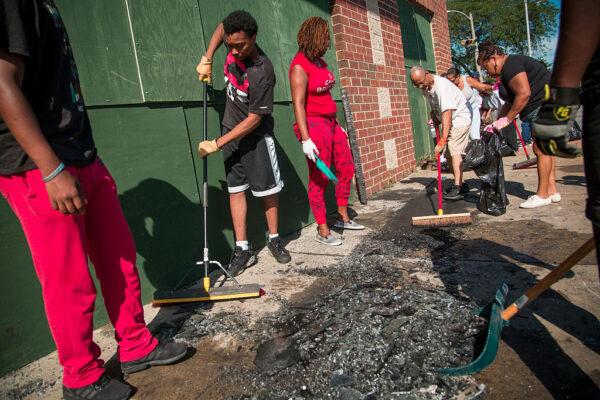 Community members and volunteers help clean up the damage to local businesses after rioters clashed with the Milwaukee Police Department protesting an officer-involved killing in Milwaukee, Wis., on Aug. 14, 2016. (Darren Hauck/Getty Images)
