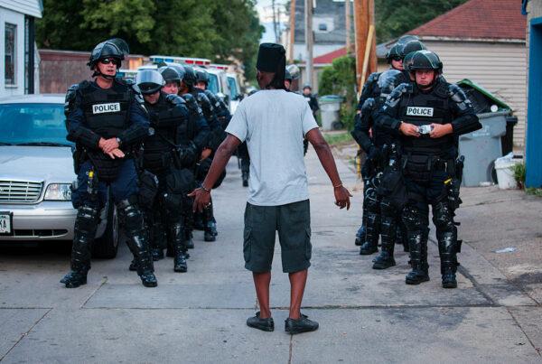 A man talks to police in riot gear as they wait in an alley after a night of clashes with protesters angry about the police shooting of Sylville Smith, in Milwaukee, on Aug. 15, 2016. (Darren Hauck/Getty Images)