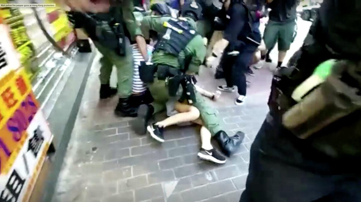 A 12-year-old girl is tackled to the ground by police in Hong Kong, on Sept. 06, 2020. (Mak Wai Kit/HKUST Radio News Reporting Team, Stand News/Screenshot via Reuters)