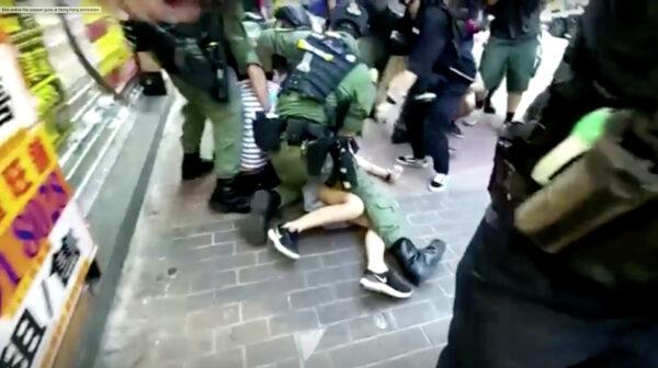 A 12-year-old girl is tackled to the ground by police in Hong Kong, on Sept. 6, 2020. (Mak Wai Kit/HKUST Radio News Reporting Team, Stand News/Screenshot via Reuters)