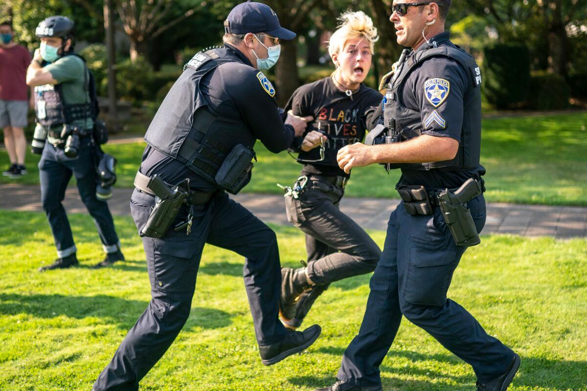  Salem police escort a counter-protester away from the scene after a clash with protesters during a rally in Salem, Ore., on Sept. 7, 2020. (Nathan Howard/Getty Images)