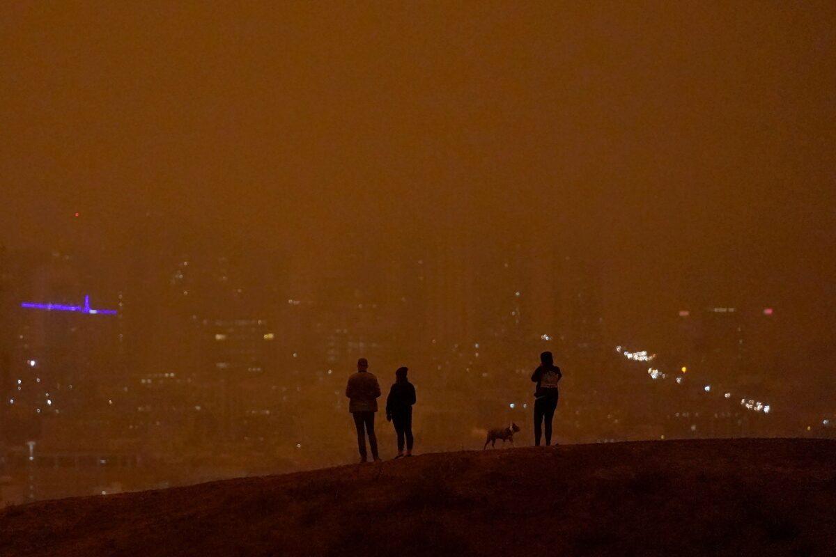 People look toward the skyline obscured by wildfire smoke in daytime from Kite Hill Open Space in San Francisco, Calif., on Sept. 9, 2020. (Jeff Chiu/(AP Photo)