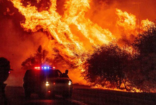 A law enforcement officer watches flames launch into the air as fire continues to spread during the Bear fire in Oroville, California, on Sept. 9, 2020. (Josh Edelson/AFP via Getty Images)