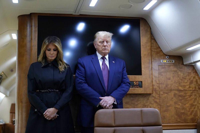 President Donald Trump and first lady Melania Trump pause for a moment of silence on Air Force One as he arrives at the airport in Johnstown, Pa., on his way to speak at the Flight 93 National Memorial, Friday, Sept. 11, 2020, in Shanksville, Pa. (AP Photo/Alex Brandon)