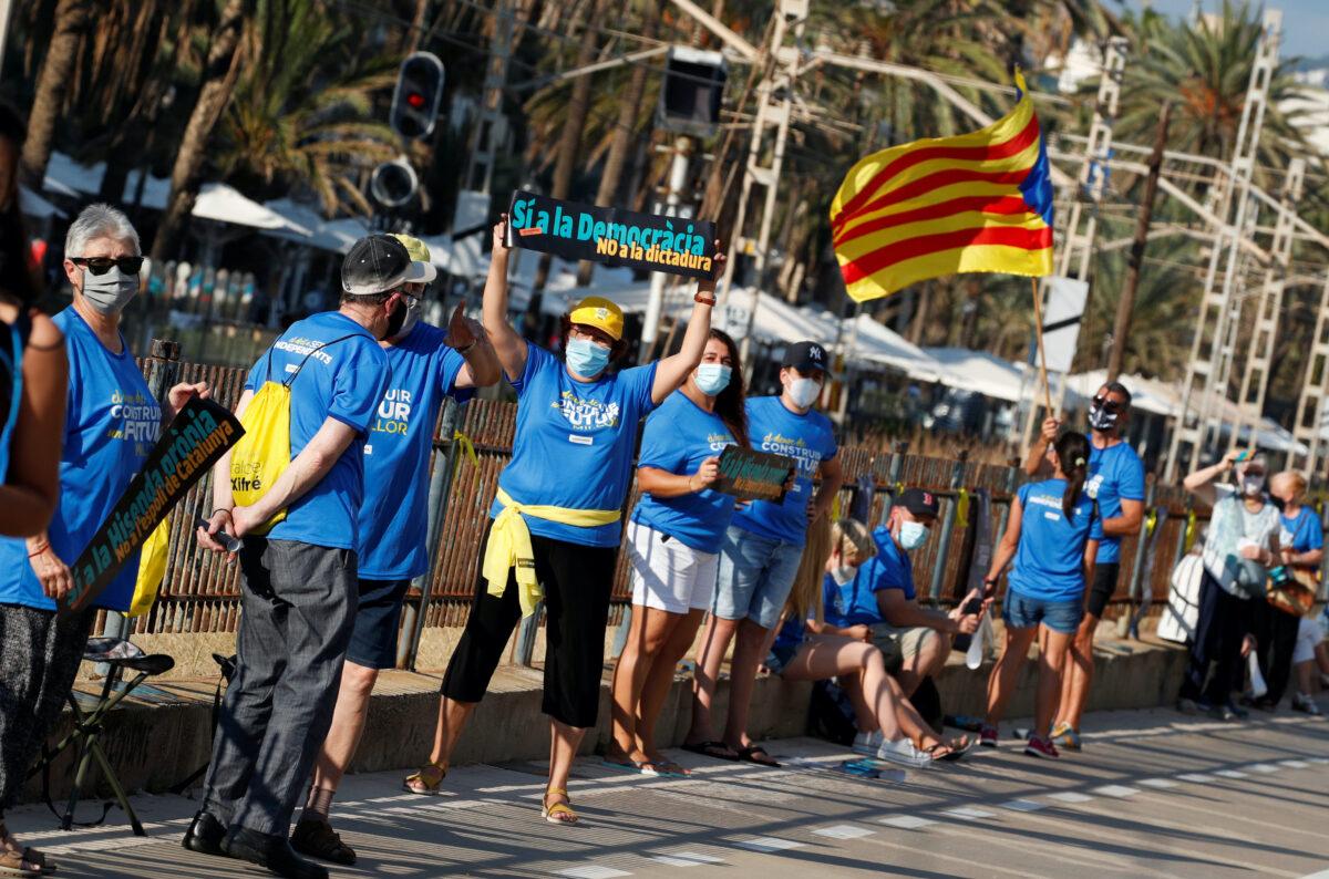 A pro-independence protester holds a placard that reads: "Yes to democracy. No to dictatorship", as she attends a rally during Catalonia's day of 'La Diada' in Badalona, Spain, on Sept. 11, 2020. (Albert Gea/Reuters)
