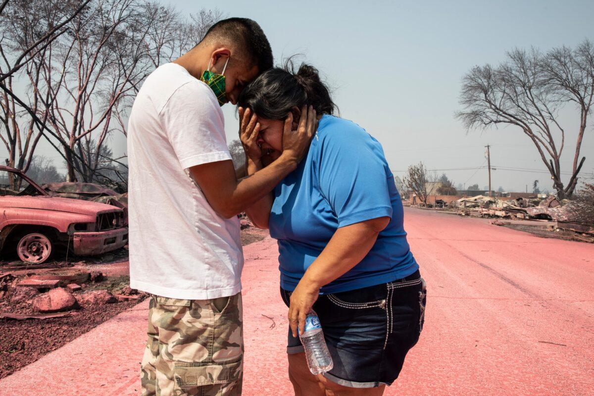 Dora Negrete is consoled by her son Hector Rocha after seeing their destroyed mobile home at the Talent Mobile Estates, in Talent, Ore., on Sept. 10, 2020. (Paula Bronstein/AP Photo)