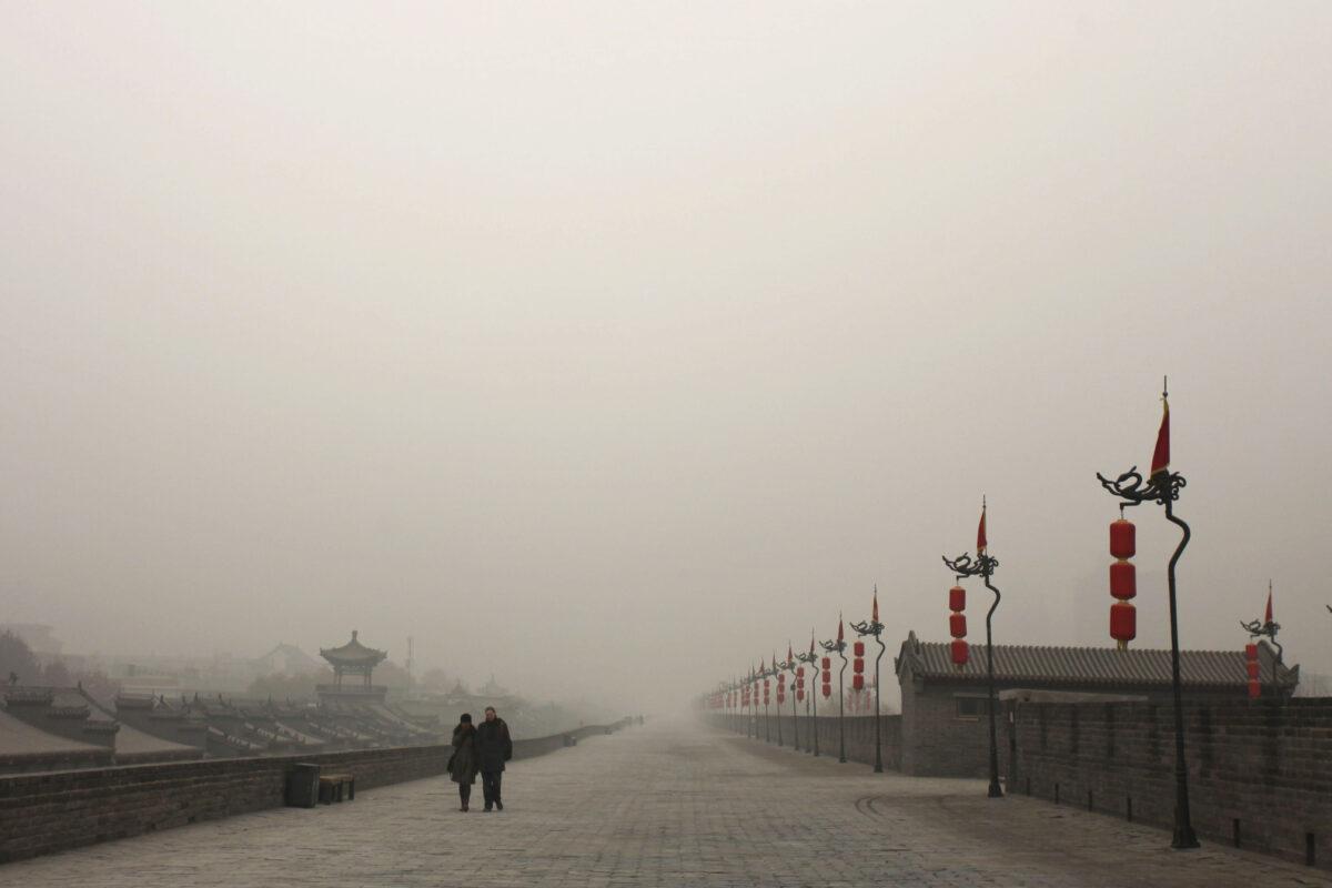 Tourists walk on the city wall as heavy smog engulfs the city in Xi'an, China, on Dec. 18, 2013. (Getty Images)