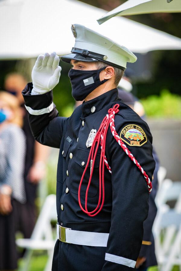 An Orange County Fire Authority officer salutes his fallen brethren at the annual 9/11 commemoration ceremony at the Richard Nixon Library and Museum in Yorba Linda, Calif., on Sept. 11, 2020. (John Fredricks/The Epoch Times)