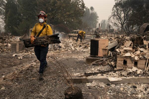 Jackson County District 5 firefighter Captain Aaron Bustard works on a smoldering fire in a burned neighborhood in Talent, Ore., Friday, Sept. 11, 2020, as destructive wildfires devastate the region. (Paula Bronstein/AP Photo)