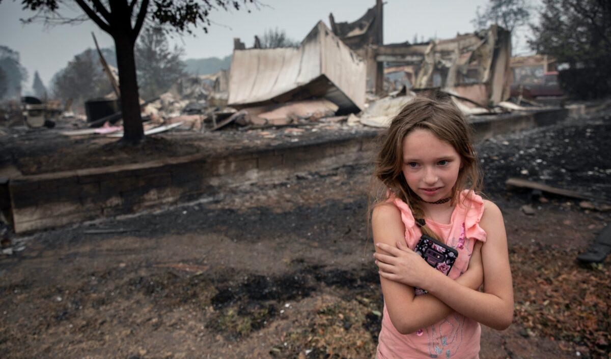 Ellie Owens, 8, from Grants Pass, Ore., looks at fire damage as destructive wildfires devastate the region in Talent, Ore., on Sept. 11, 2020. (Paula Bronstein/AP Photo)