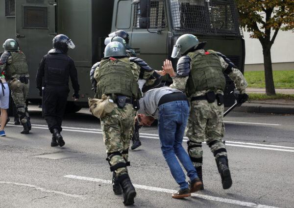 Law enforcement officers detain a protester during a rally against police brutality following protests to reject the presidential election results in Minsk, Belarus, on Sept. 13, 2020. (Tut.By/Reuters)