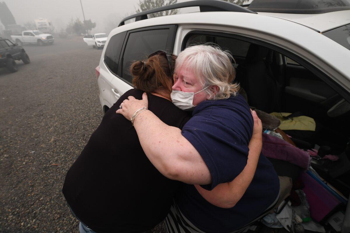  Margi Wyatt (R) is comforted by mobile home park manager Valerie after Wyatt returned to the R.V. park to find her home destroyed by wildfire, in Estacada, Ore., on Sept. 12, 2020. (Robyn Beck/AFP via Getty Images)