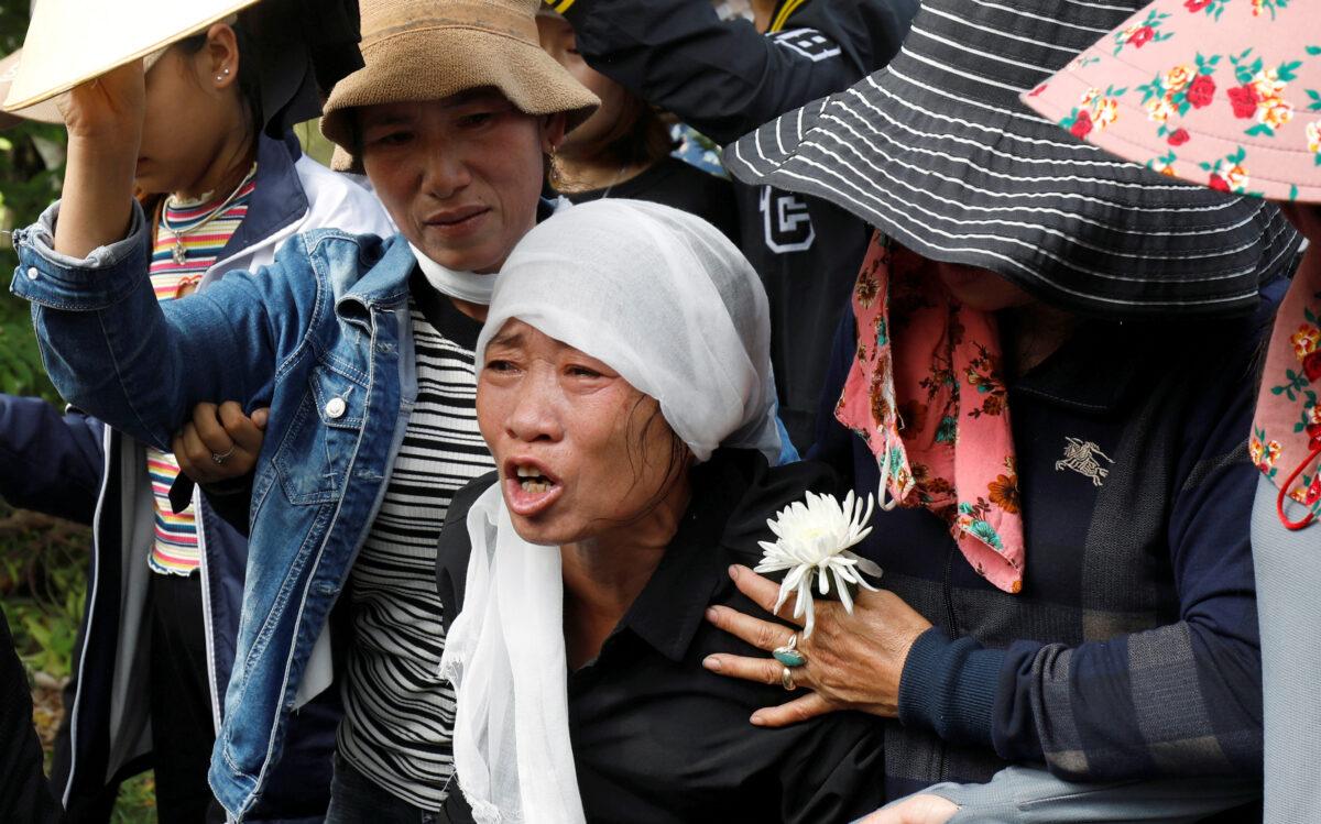 Tran Thi Hien, mother of Anna Bui Thi Nhung, one of 39 Vietnamese people found dead in a truck in England in October 2019, cries while following an ambulance carrying her daughter's coffin during the funeral ceremony at her village in Nghe An province, Vietnam, on Nov. 30, 2019. (Kham/Reuters)