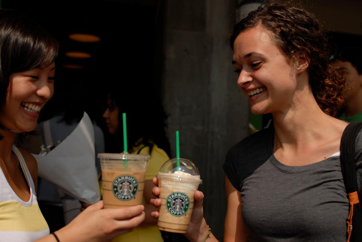 Janice Kim (L) of Seattle and Katie Schaumann of Minnesota drink Starbucks coffees outside of the flagship Starbucks store at Pike Place July 1, 2008 in Seattle, Wash. (Melanie Conner/Getty Images)