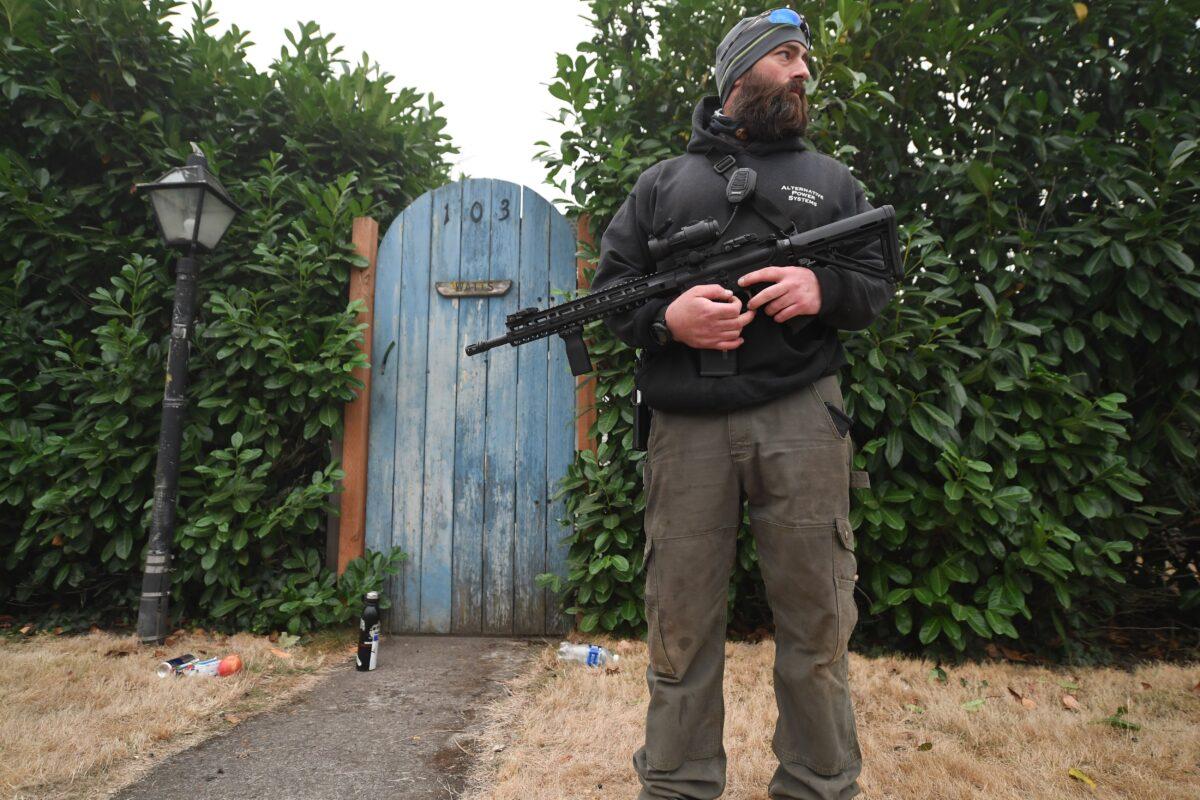 Matt Watts stands guard with firearms outside his home after wildfires and heavy smoke caused many of his neighbors to evacuate the area, in Estacada, Ore., on Sept. 12, 2020. (Robyn Beck/AFP via Getty Images)
