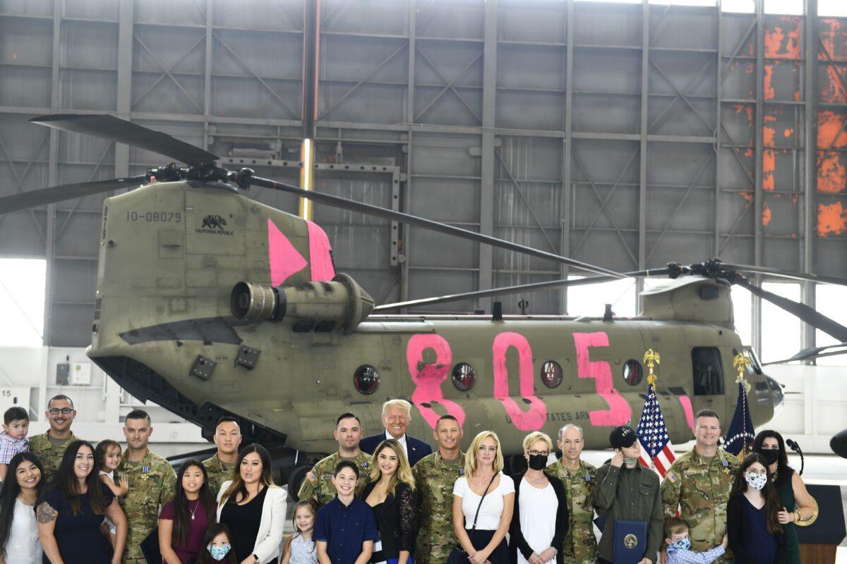 President Donald Trump poses with pilots and crew members of the California Army National Guard and their families at Sacramento McClellan Airport in McClellan Park, Calif., on Sept. 14, 2020. (Brendan Smialowski/AFP via Getty Images)