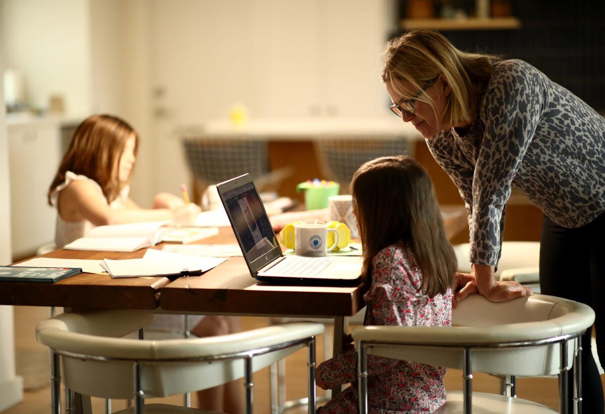 A woman helps her kindergarten daughter with schoolwork at home in San Anselmo, Calif. on March 18, 2020. (Ezra Shaw/Getty Images)