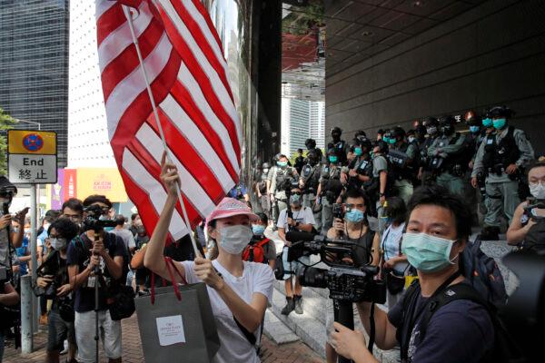 A woman carries an American flag during a protest outside the U.S. Consulate in Hong Kong, China, on July 4, 2020. (Kin Cheung/ File/AP Photo)