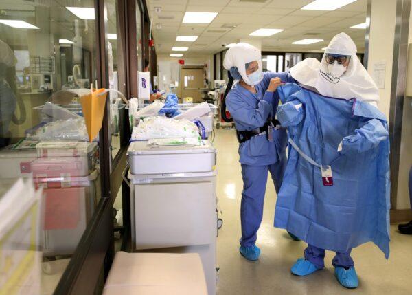  A nurse helps a doctor put on his personal protective equipment (PPE) before performing a procedure on a coronavirus COVID-19 patient in the intensive care unit (I.C.U.) at Regional Medical Center in San Jose, Calif., on May 21, 2020. (Justin Sullivan/Getty Images)