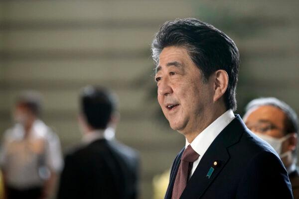 Japan's outgoing Prime Minister Shinzo Abe speaks to the media as he arrives at the prime minister's office for a cabinet meeting, in Tokyo, Japan, on Sept. 16, 2020. (AP Photo/Eugene Hoshiko)